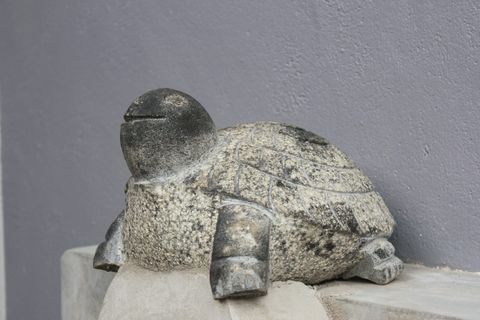 A carved stone turtle ornament on a shelf at EKA Beach