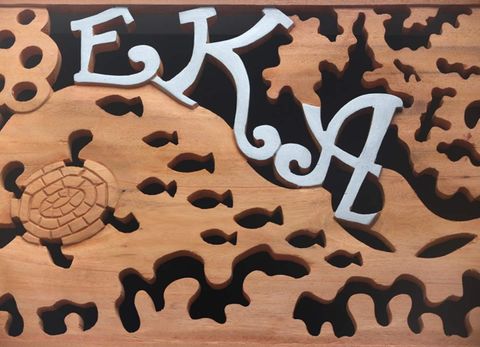 The carved wooden EKA sign at the entrance to EKA Beach