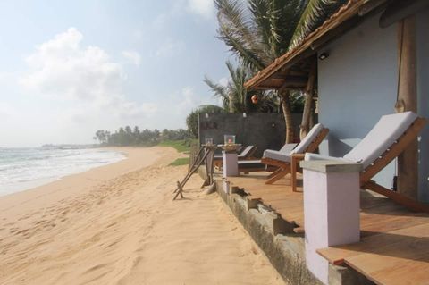 Sun loungers and palms on the golden sand in front of EKA Beach, Talpe